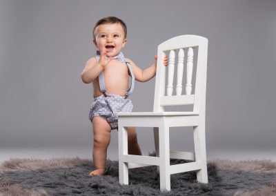 Baby-Standing-againts-Chair-studio-portrait