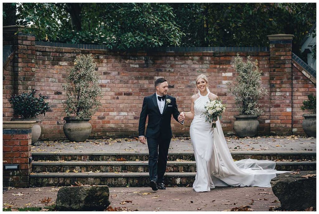 Bride walking through Fairlawns Hotel gardens in autumn