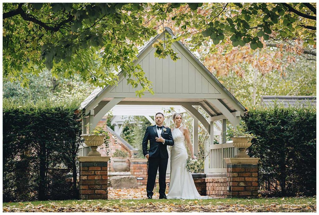 Bride walking through Fairlawns Hotel gardens in autumn